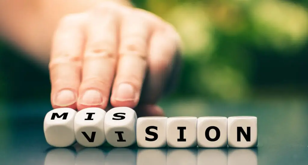 From a vision to a mission. Hand turns dice and changes the word