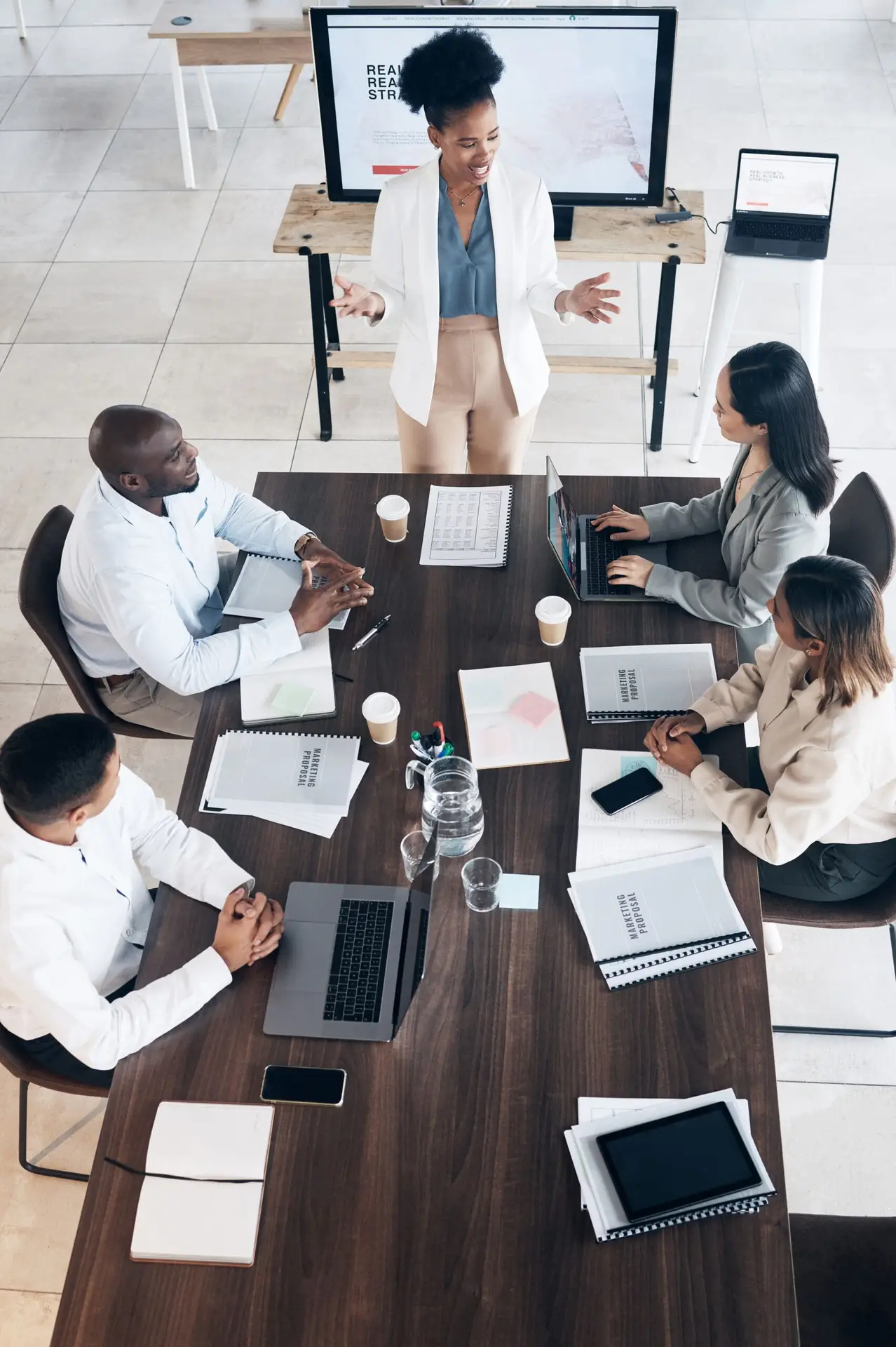 Business meeting, presentation and people above for conference, seminar or workshop in corporate training. Professional black woman, manager or speaker speaking to clients, employees or company staff.